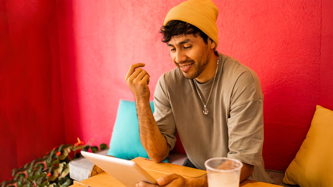 man in beanie working on laptop